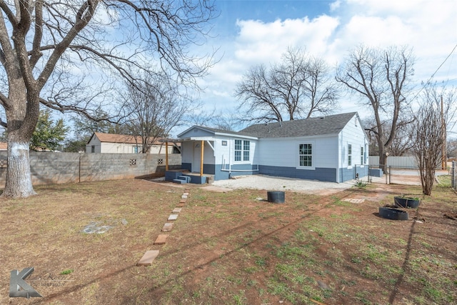 back of house featuring a gate and fence