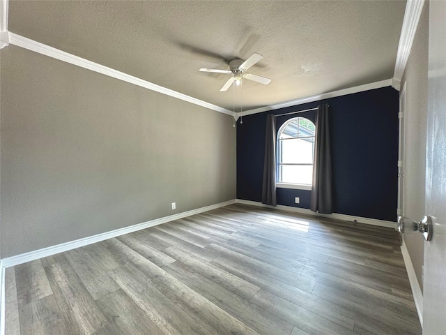 spare room featuring ornamental molding, wood finished floors, and baseboards