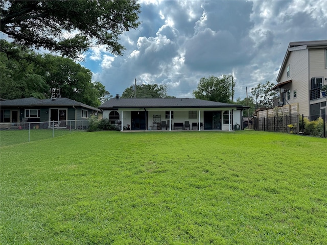 rear view of house featuring a yard and a fenced backyard