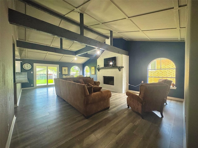 living area featuring lofted ceiling with beams, a fireplace, wood finished floors, and baseboards