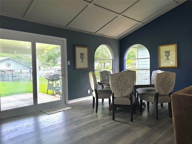 dining area featuring baseboards, vaulted ceiling, and wood finished floors