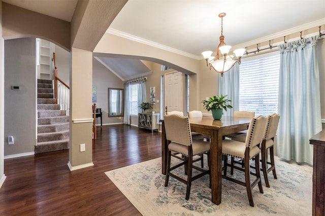 dining area featuring wood finished floors, baseboards, arched walkways, stairs, and crown molding