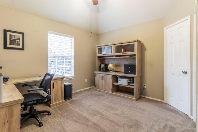 carpeted office with lofted ceiling and baseboards