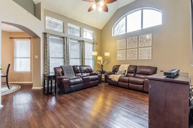 living area with high vaulted ceiling, a ceiling fan, baseboards, and dark wood-style flooring