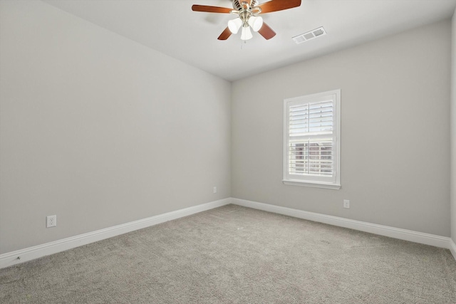 carpeted empty room featuring a ceiling fan, visible vents, and baseboards