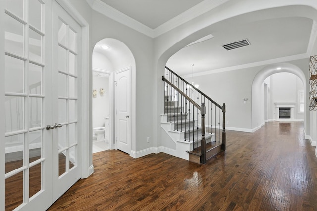 entrance foyer featuring visible vents, baseboards, stairway, dark wood finished floors, and crown molding