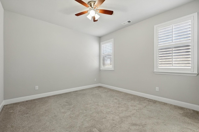 empty room featuring carpet flooring, visible vents, and baseboards