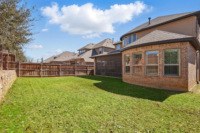 view of yard with a sunroom and a fenced backyard