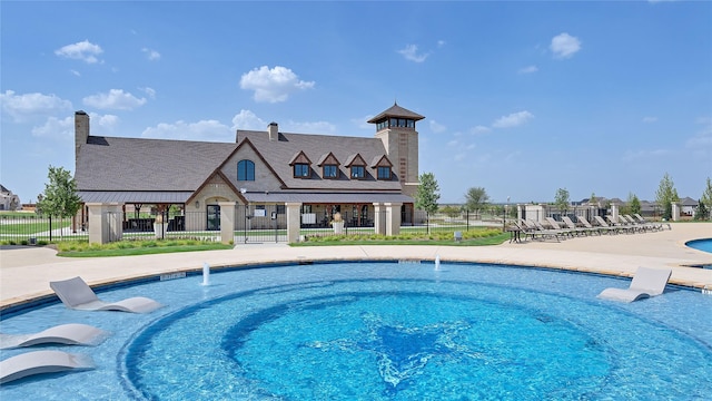 community pool with a patio and fence