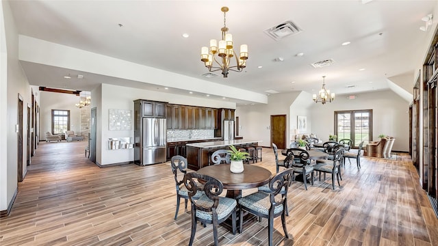 dining space featuring a chandelier, a wealth of natural light, light wood-style flooring, and visible vents