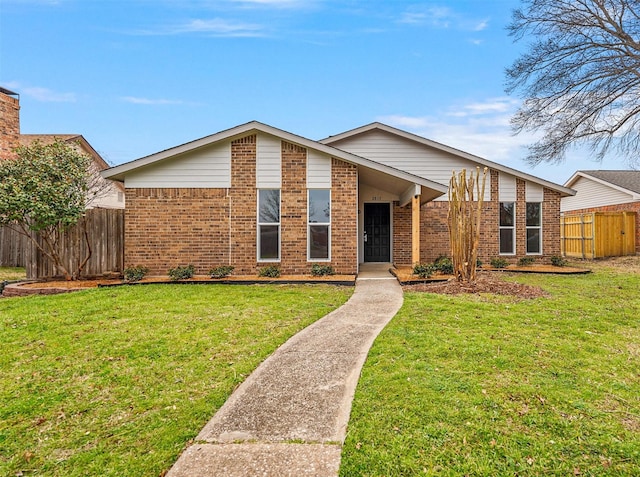 mid-century inspired home featuring brick siding, a front yard, and fence