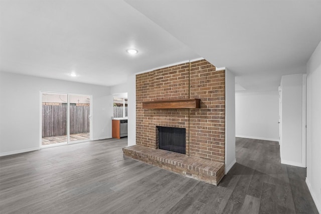 unfurnished living room with a fireplace, baseboards, and wood finished floors