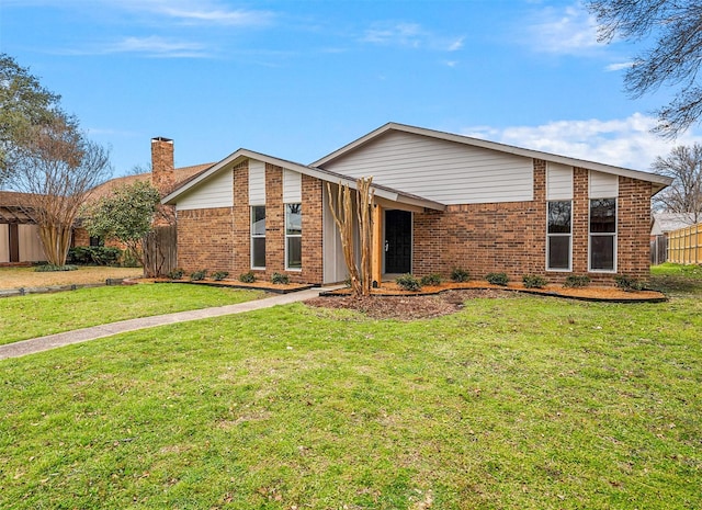 mid-century home with brick siding, fence, a chimney, and a front lawn