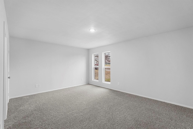 unfurnished room with carpet flooring and baseboards