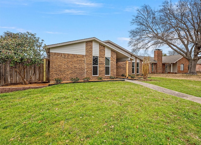 view of front of property featuring a front yard, brick siding, and fence