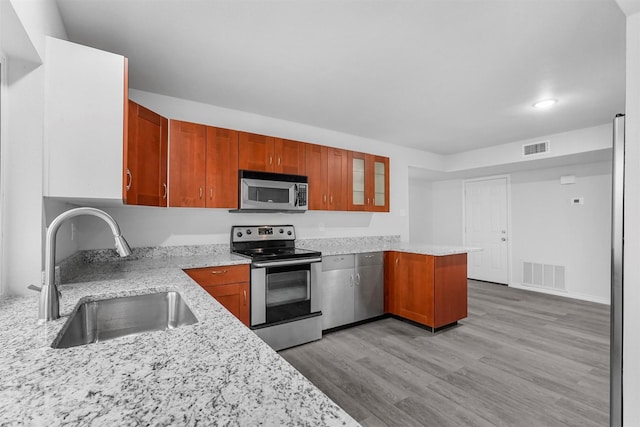 kitchen with appliances with stainless steel finishes, light wood-style floors, visible vents, and a sink