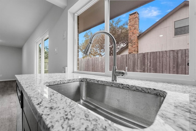 room details with baseboards, light stone counters, and a sink