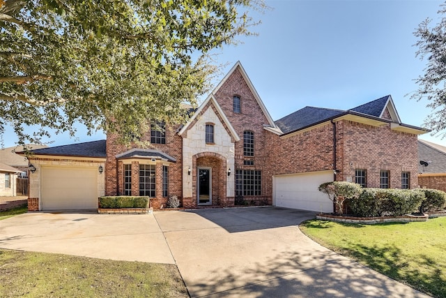 view of front of home with driveway, brick siding, and a front lawn