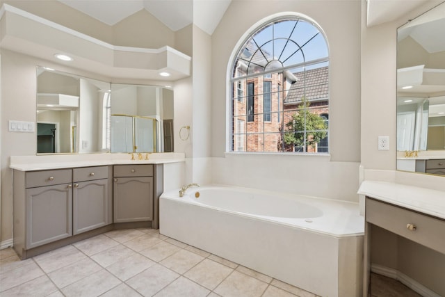 bathroom featuring a wealth of natural light, tile patterned floors, vaulted ceiling, and a bath