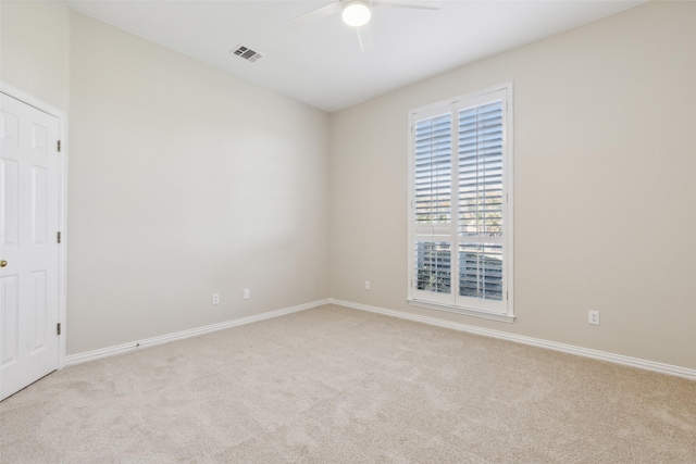 spare room with ceiling fan, carpet flooring, visible vents, and baseboards