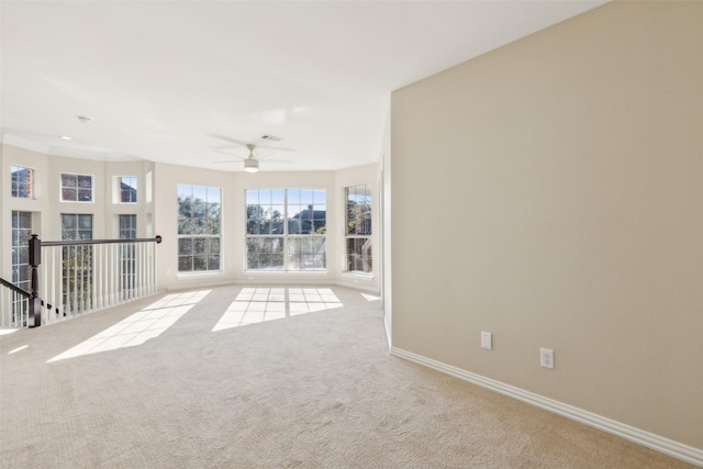 carpeted spare room featuring visible vents, baseboards, and a ceiling fan