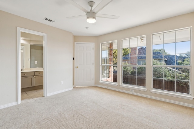 unfurnished bedroom featuring visible vents, a ceiling fan, light carpet, connected bathroom, and baseboards