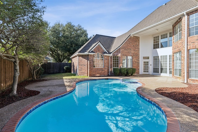 view of pool featuring a patio, a fenced backyard, and a pool with connected hot tub