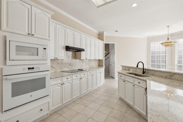 kitchen featuring under cabinet range hood, white appliances, a sink, ornamental molding, and decorative backsplash