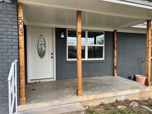 property entrance featuring brick siding