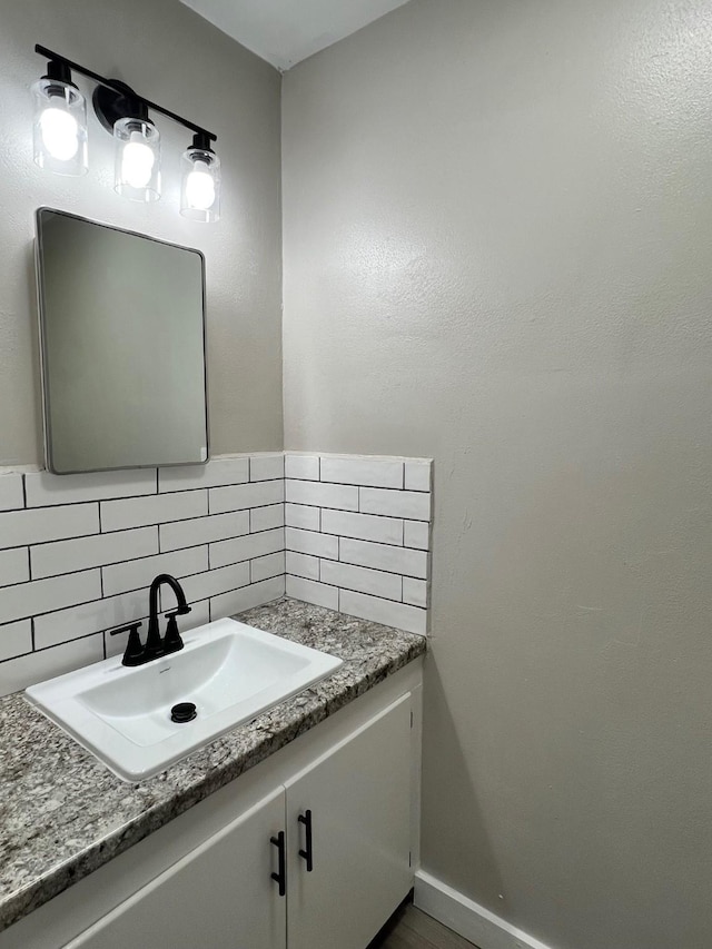 bathroom featuring baseboards, vanity, and decorative backsplash