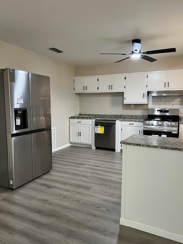 kitchen with visible vents, wood finished floors, stainless steel appliances, under cabinet range hood, and white cabinetry