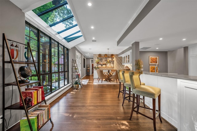 interior space featuring a skylight, decorative backsplash, wood finished floors, and recessed lighting