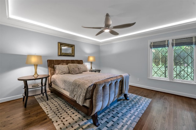 bedroom with ceiling fan, crown molding, baseboards, and wood finished floors