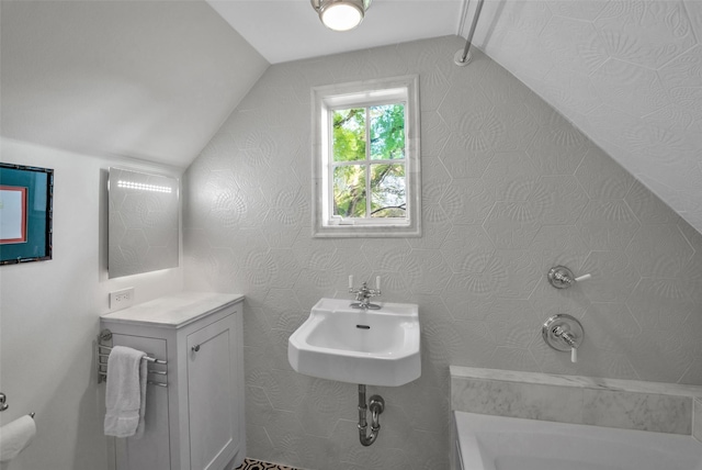 bathroom with walk in shower, vaulted ceiling, a sink, and a bath