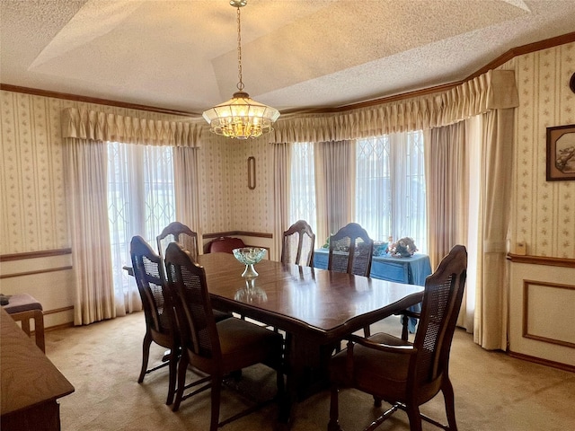 dining area featuring wallpapered walls, a textured ceiling, and wainscoting