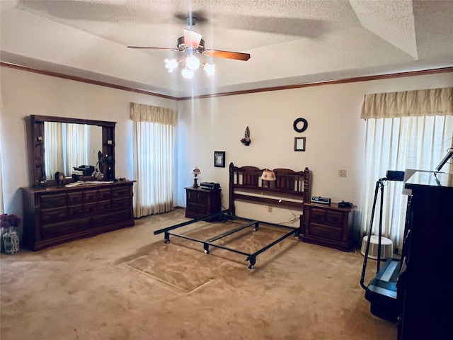 carpeted bedroom with a textured ceiling, ornamental molding, a raised ceiling, and a ceiling fan