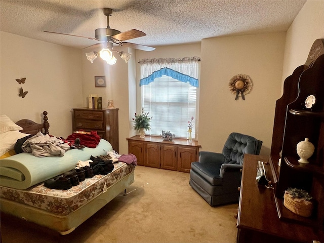 bedroom with light colored carpet, ceiling fan, and a textured ceiling