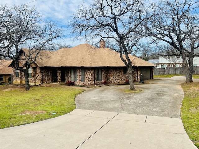 view of front of home featuring concrete driveway, a chimney, fence, a front lawn, and brick siding