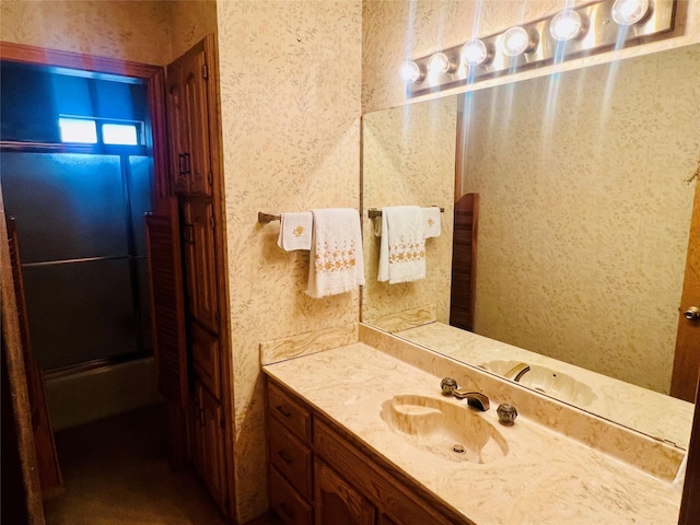 bathroom featuring vanity and wallpapered walls