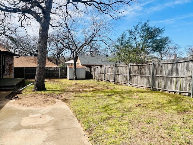 view of yard featuring an outbuilding, a fenced backyard, and a storage unit