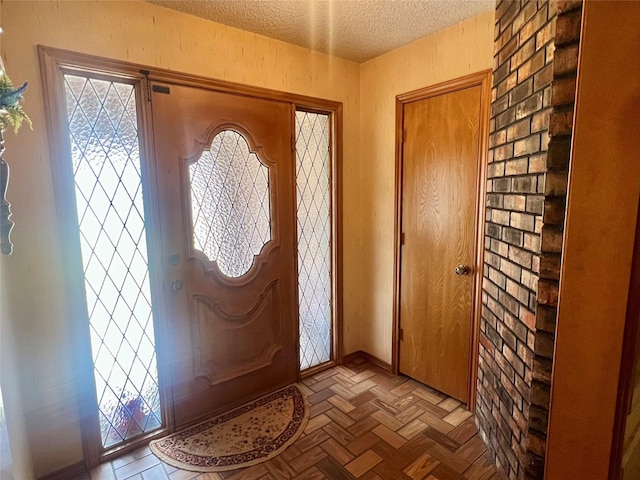 entryway with plenty of natural light, a textured ceiling, and baseboards