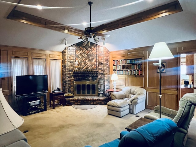 carpeted living room with vaulted ceiling with beams, a brick fireplace, a ceiling fan, and wood walls