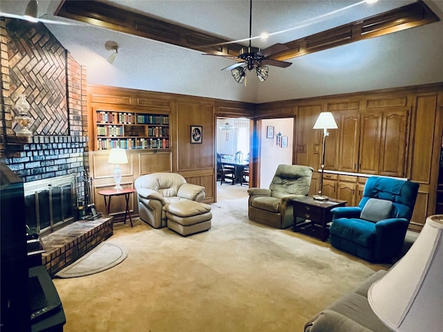 carpeted living room with wood walls, ceiling fan, and a fireplace