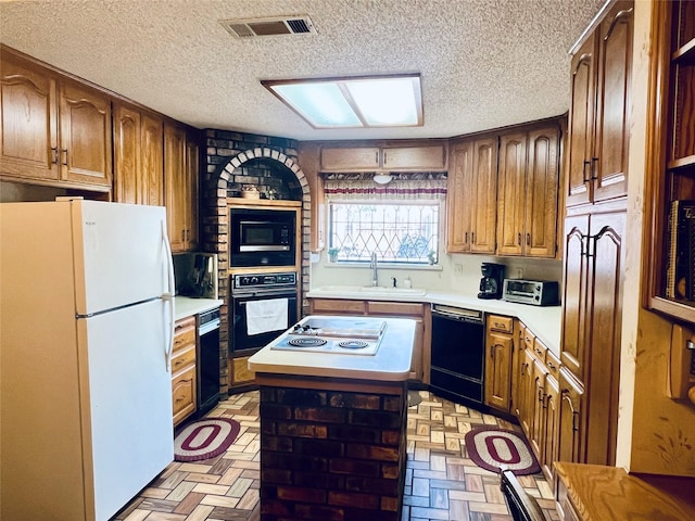 kitchen featuring a center island, light countertops, visible vents, a sink, and black appliances