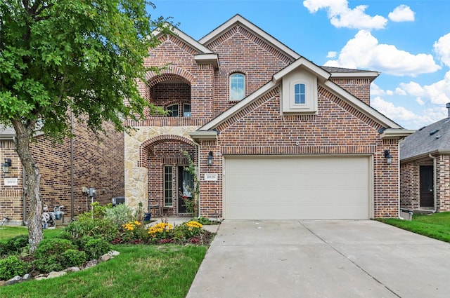 view of front of house featuring an attached garage, concrete driveway, and brick siding