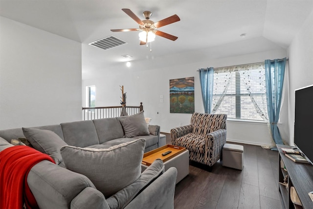 living room with ceiling fan, visible vents, and dark wood-type flooring