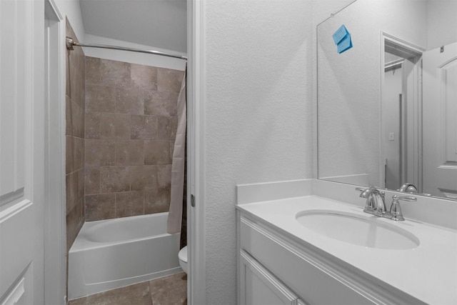 full bath featuring a textured wall, shower / tub combo with curtain, vanity, and toilet