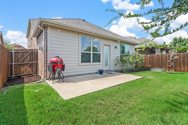 back of property featuring a lawn, a patio area, a fenced backyard, and a gate