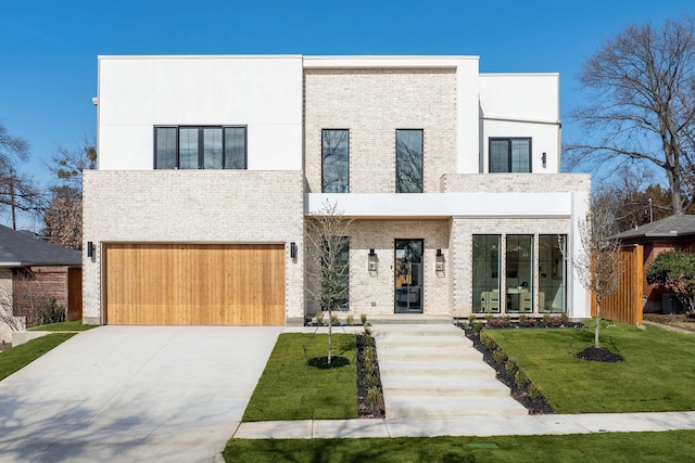 modern home with a front lawn, stucco siding, concrete driveway, brick siding, and a garage