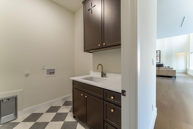 clothes washing area featuring hookup for a washing machine, cabinet space, a sink, baseboards, and tile patterned floors